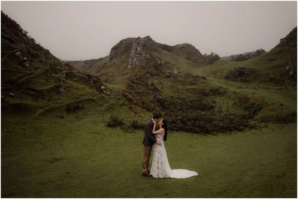 Couple sharing a kiss after their vow renewal ceremony in the valley at Fairy Glen, Isle of Skye