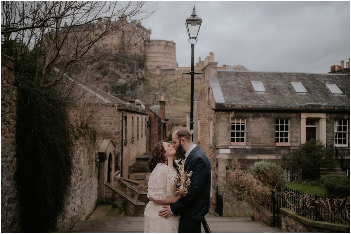 Newlyweds sharing a kiss at the Vennel Viewpoint 