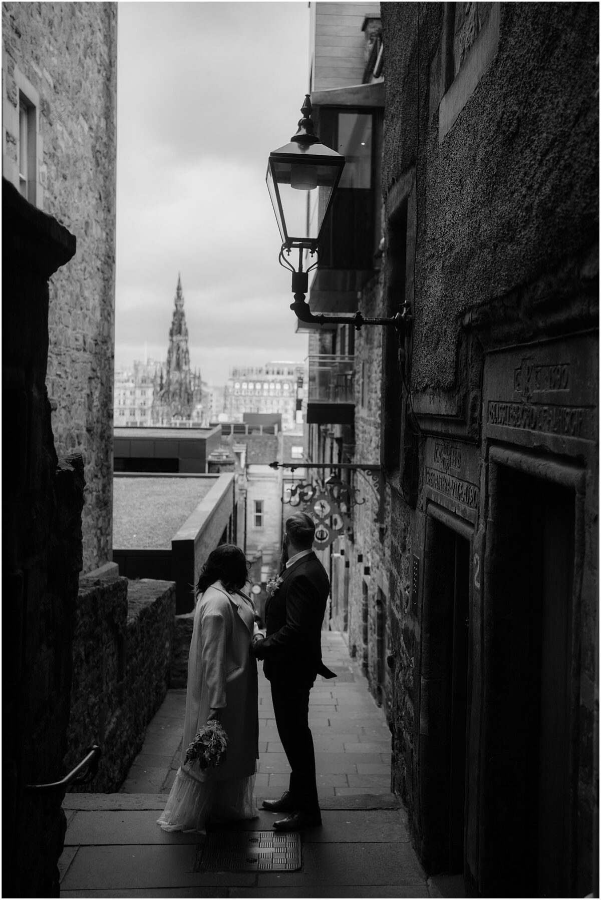 Newlywed couple in black and white standing in Advocate's Close