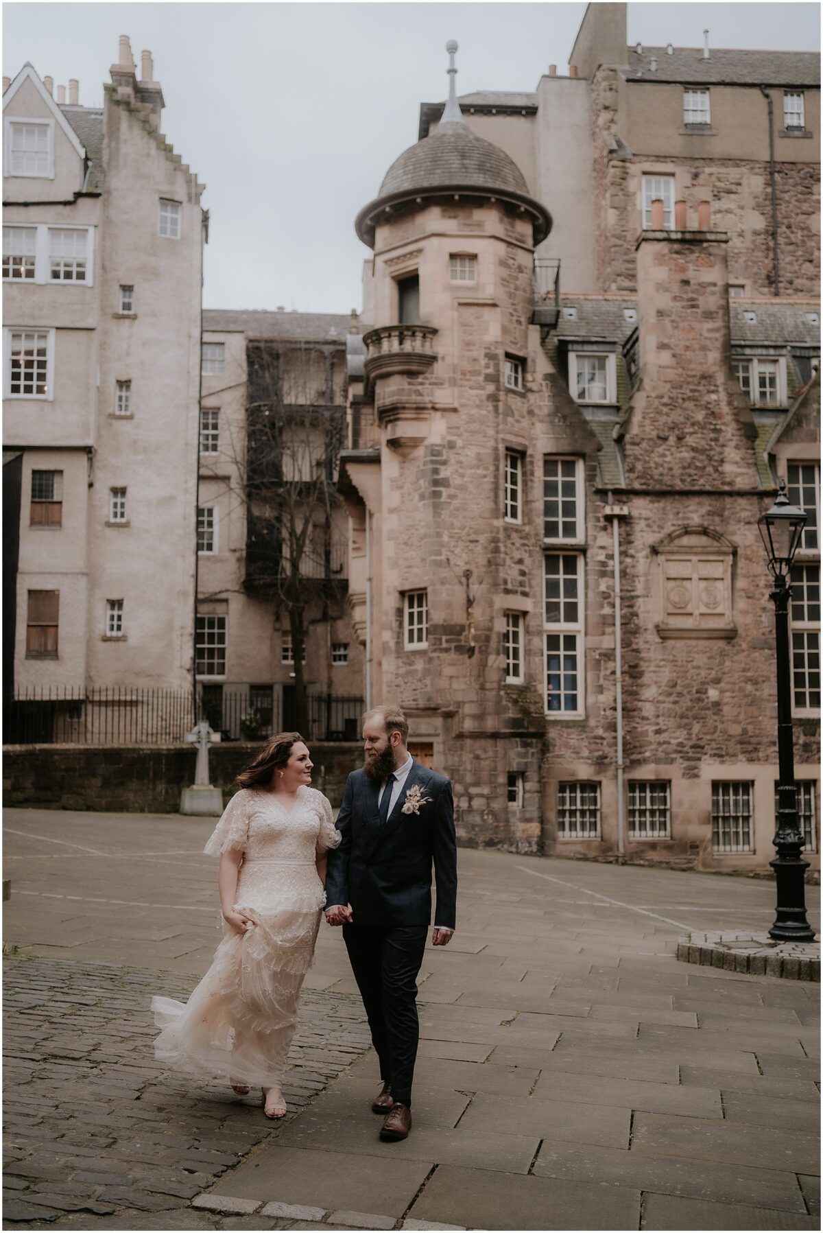 Bride and groom holding hands and walking at Lady Stair's Close in the city centre