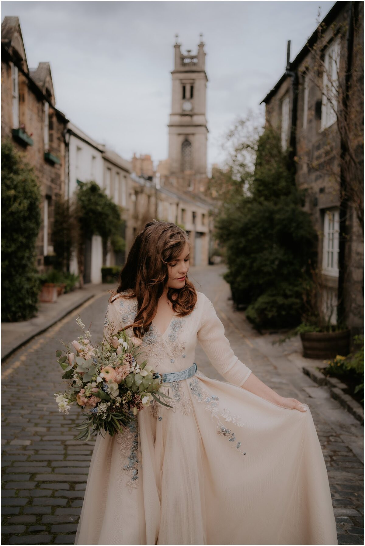 Portraits of the bride touching her Teuta Matoshi wedding gown and looking down at the train and holding bouquet in another hand