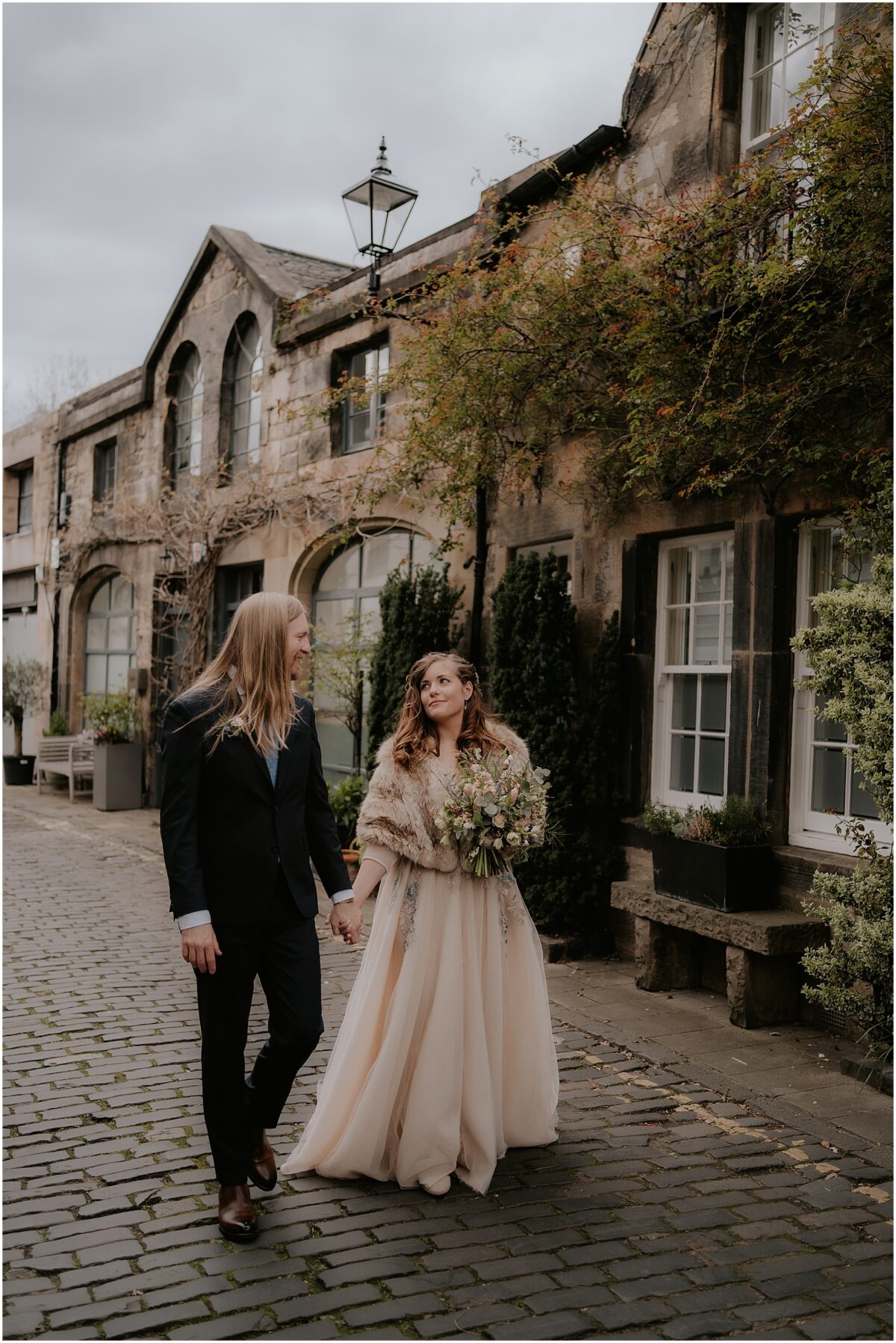 Bride and groom walking down the Circus Lane in Edinburgh, holding hands