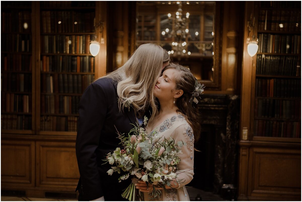 Bride and groom sharing an intimate moment at the venue, bride closes her eyes whilst cuddling into her husband