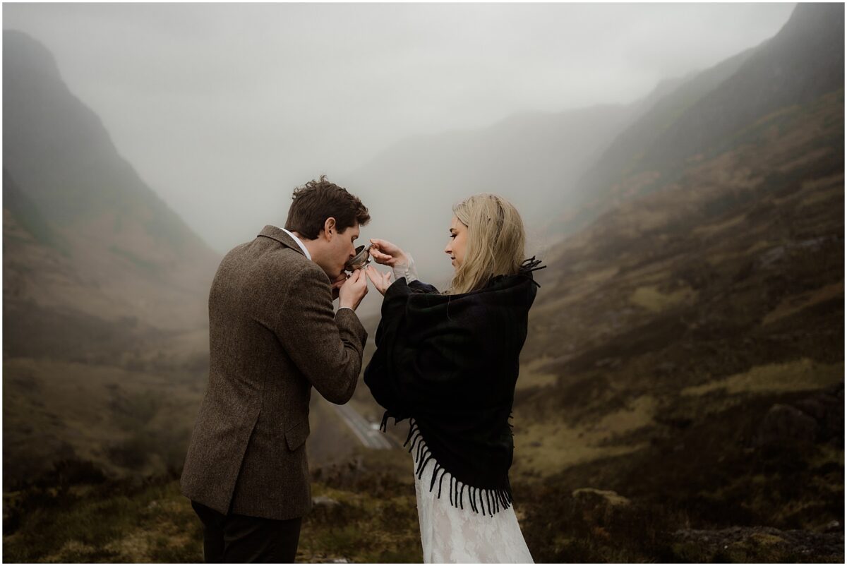 Groom drinking from a silver quaich cup held by the bride as they celebrate their ceremony in the Highlands