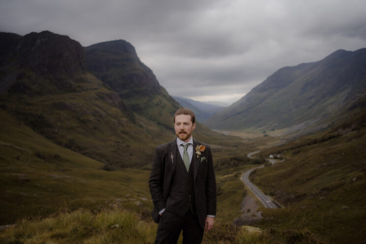 Groom wearing a tweed suit at a Scottish outdoor wedding
