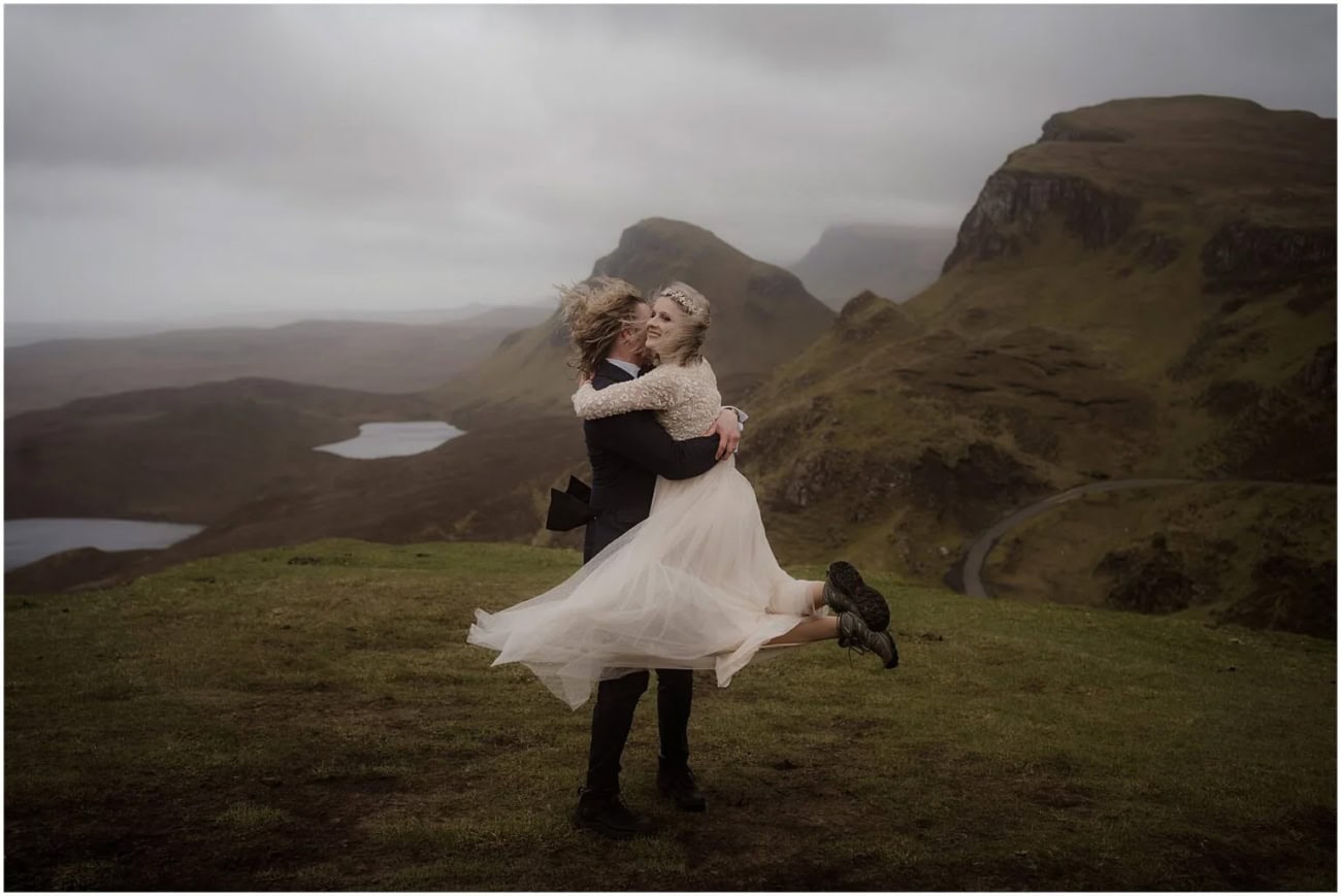 Quiraing elopement on Isle of Skye, Scotland Groom lifting and embracing his bride on a misty hilltop at the Quiraing