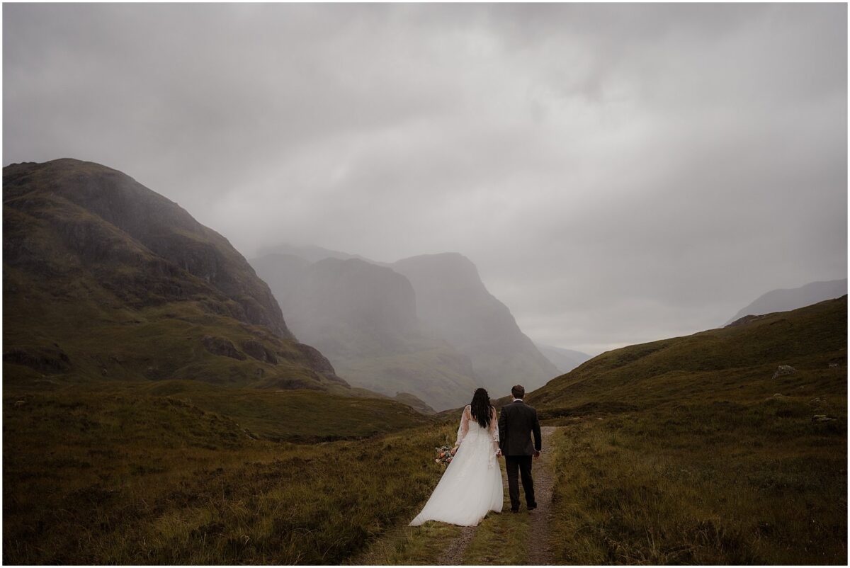 Glencoe wedding photos - Glencoe wedding photographer Couple ascend rocky track toward The Study Viewpoint