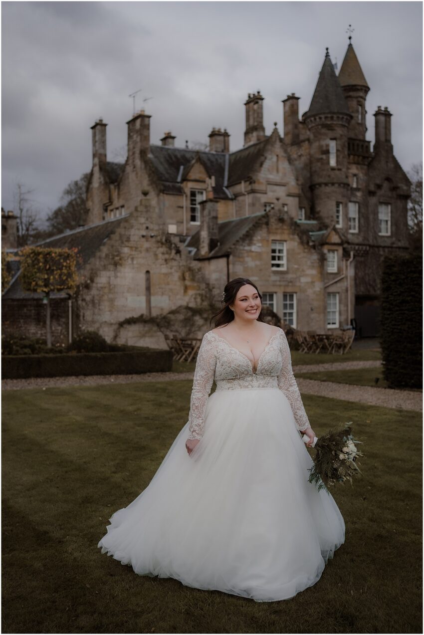 Bride posing to wedding photos at Carlowrie Castle