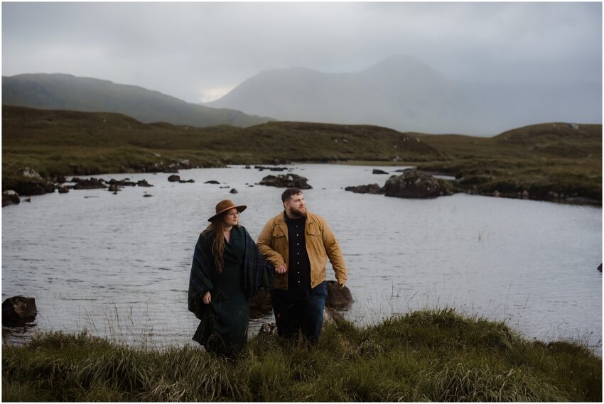 Fiances admiring the view of Scottish Highlands in the rain - Rannoch Moor engagement photos