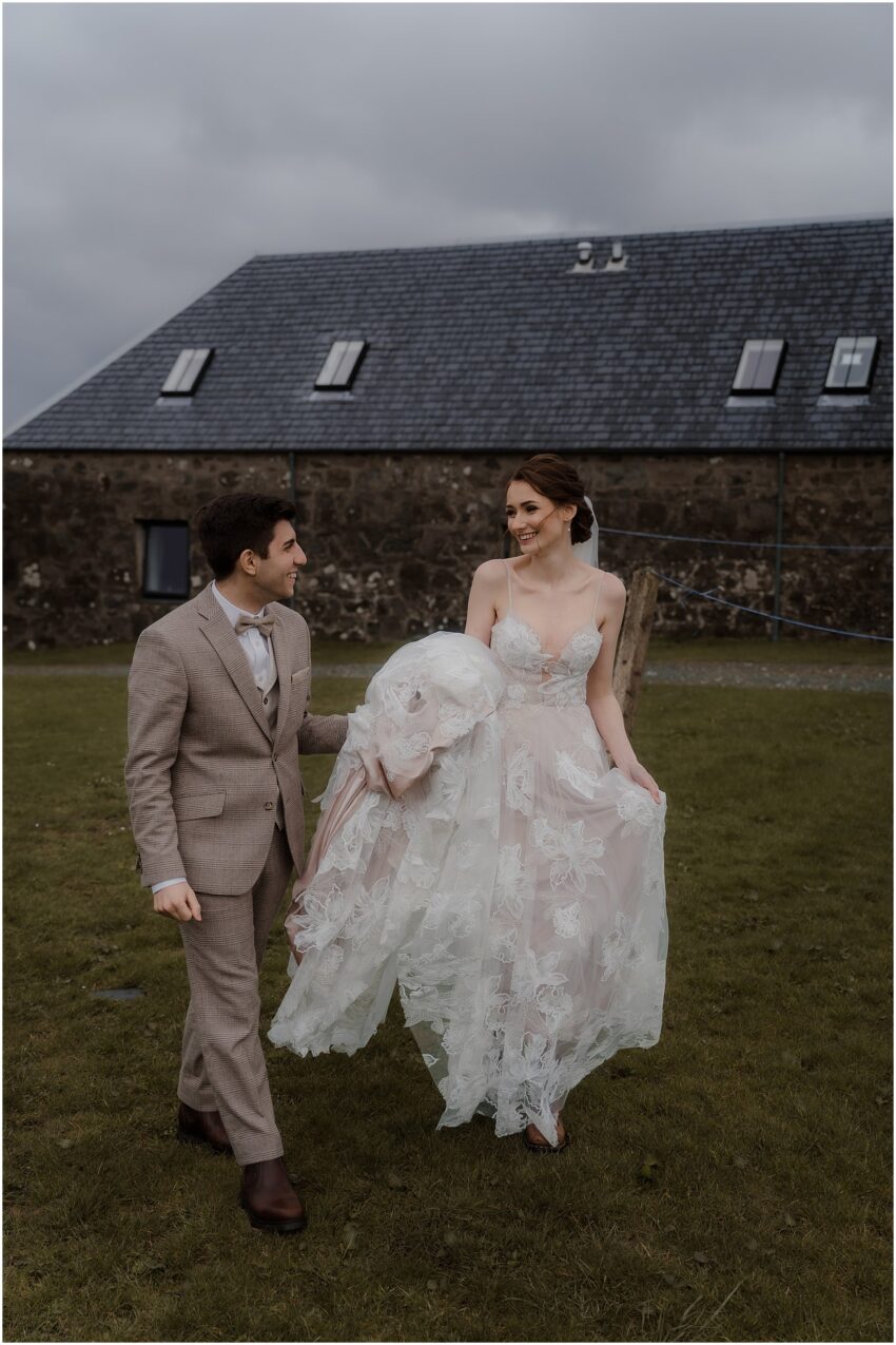 Bride and groom looking at each other lovingly outside of their Isle of Skye cottage accommodation