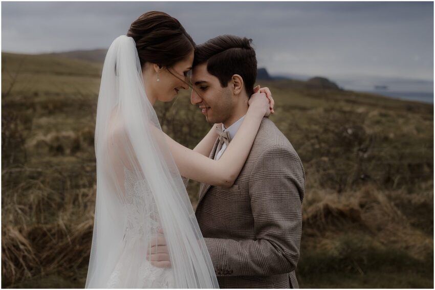 Bride and groom embracing outside of their Isle of Skye cottage accommodation
