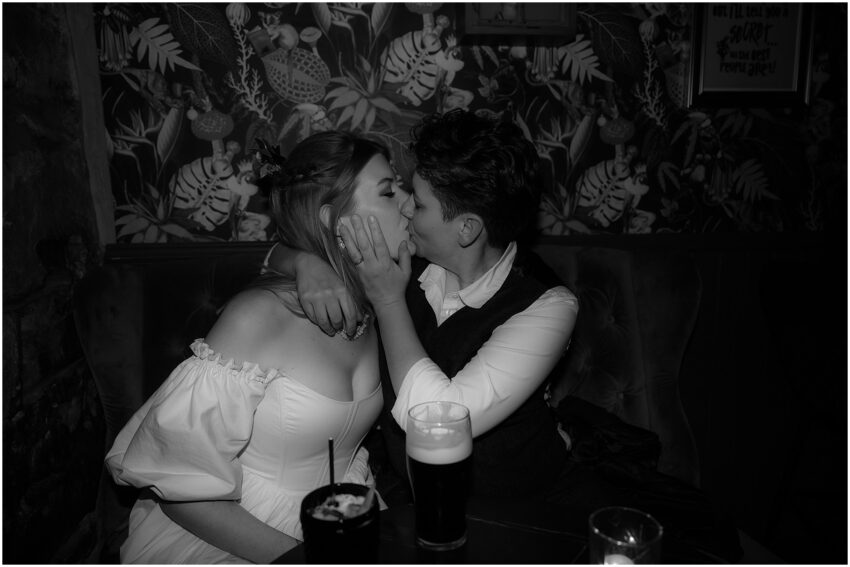 Couple kissing over a pint of Guiness and cocktails in a bar