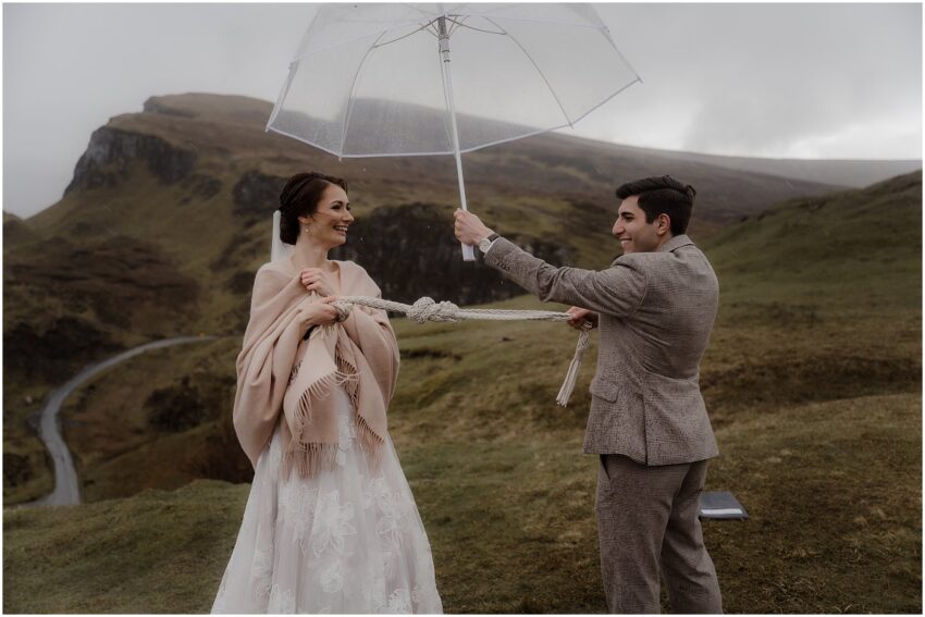 Handfasting ritual at the outdoor wedding  ceremony in the rain in Quiraing in Scotland - Isle of Skye elopement photographer
