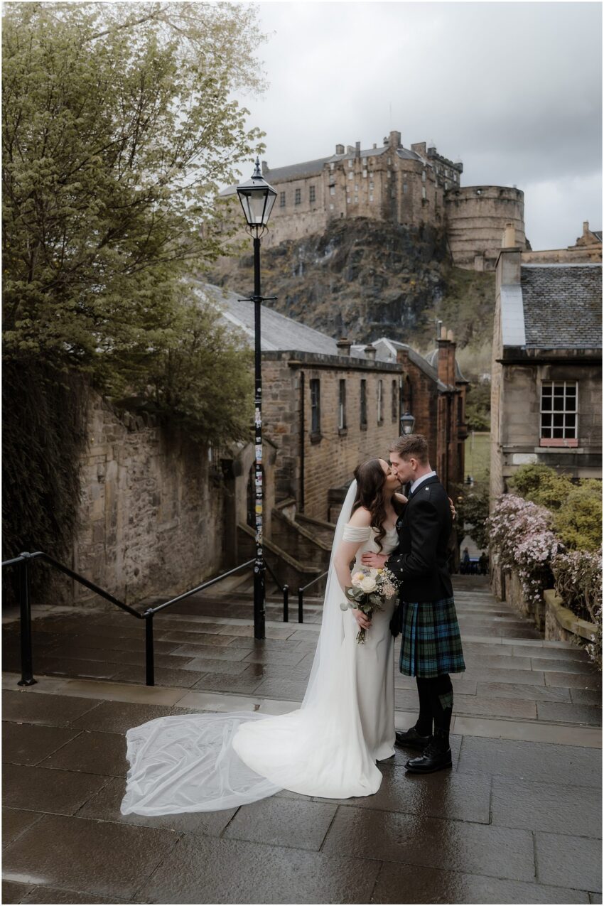 Bride and groom kissing in front of Edinburgh Castle 