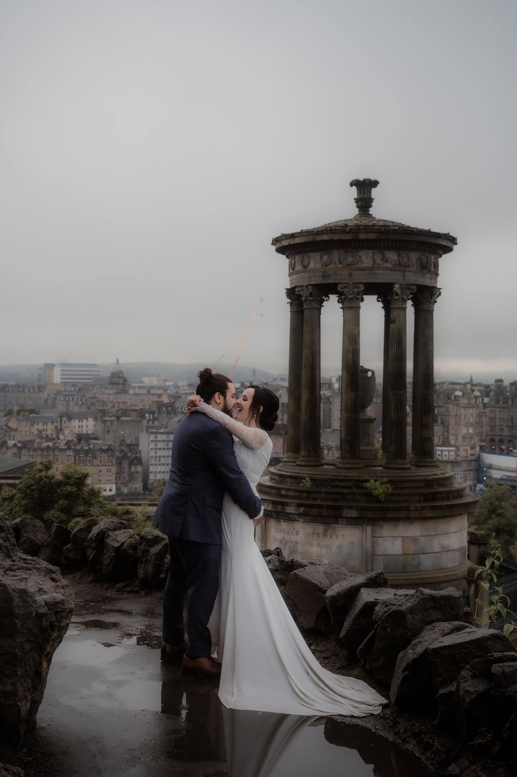 Edinburgh Royal Botanic Garden elopement 54 Bride and groom ambrace at Calton Hill on a rainy wedding day