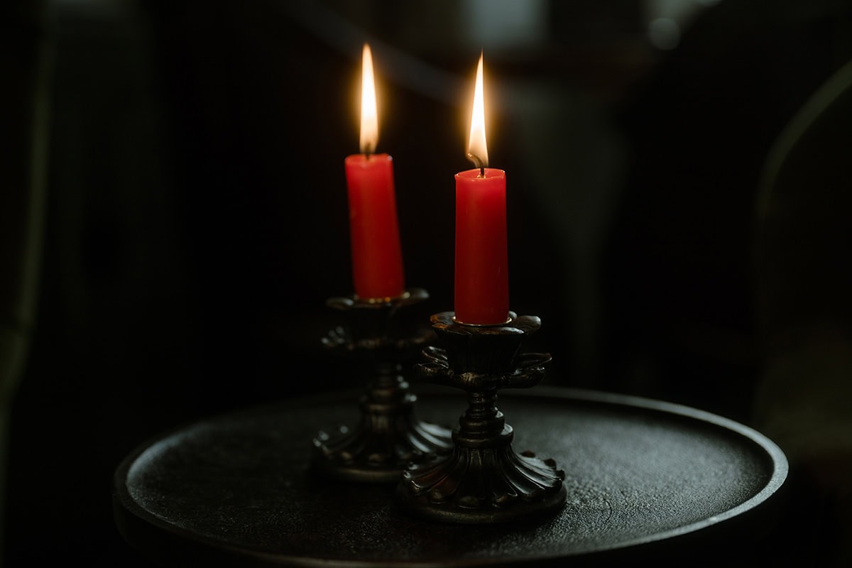 Isle of Skye Elopement Guide 2026/27 – plan your Scottish adventure wedding 30 Two red candles burning in ornate antique brass candleholders on a dark tray inside Monkstadt 1745 hotel, Isle of Skye