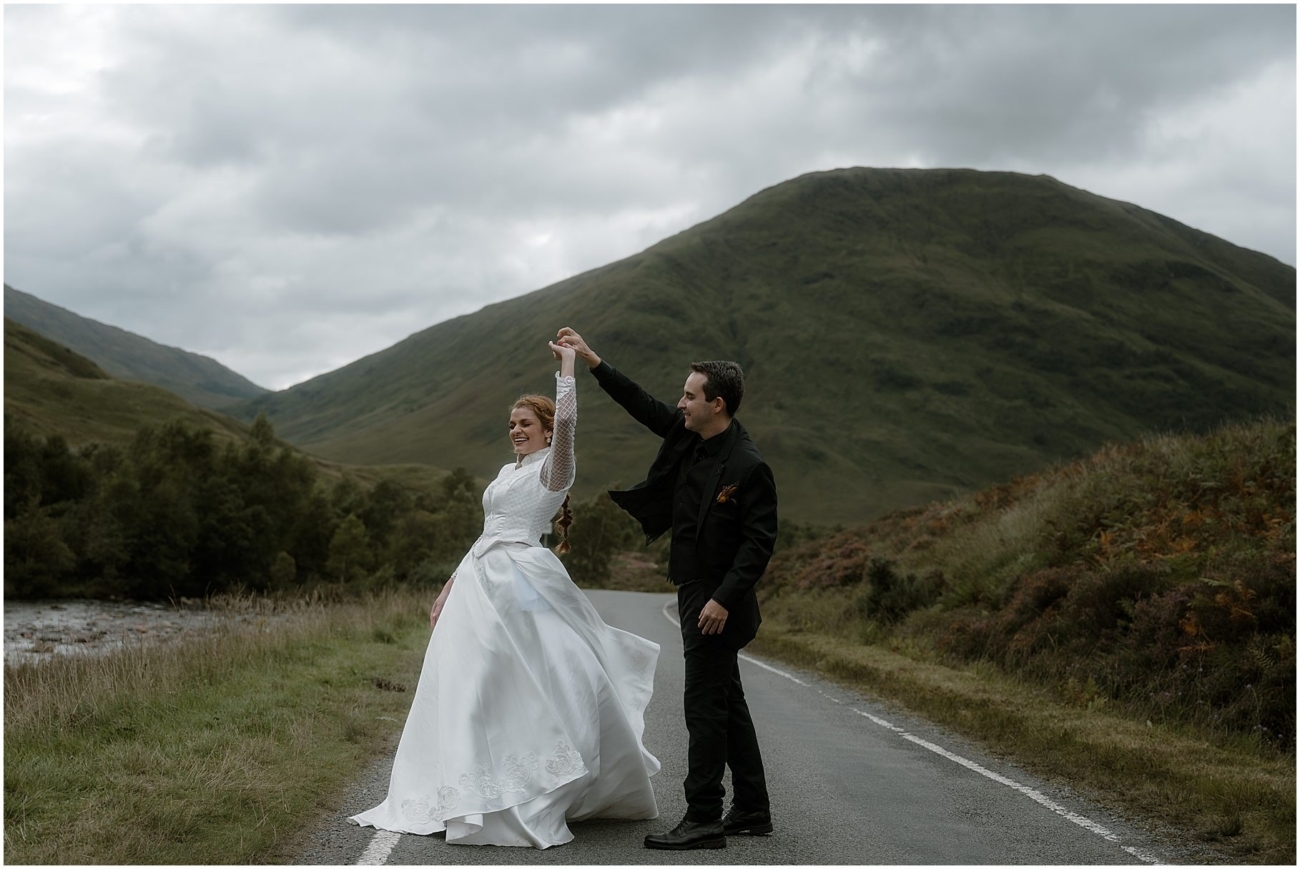 Bride and groom dancing on the road in Glencoe