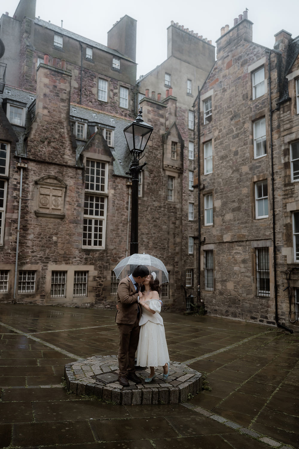 Advice for Rainy Wedding Days in Scotland - turn rain into romance 6 Newlyweds kissing in the rain in front of the Writer's Museum in Edinburgh