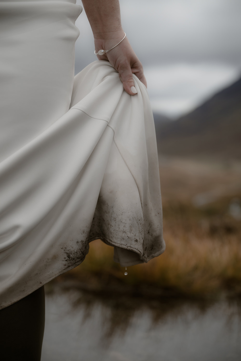Advice for Rainy Wedding Days in Scotland - turn rain into romance 9 Bride holding the rain of her dress with water drops falling off the train of wet wedding dress