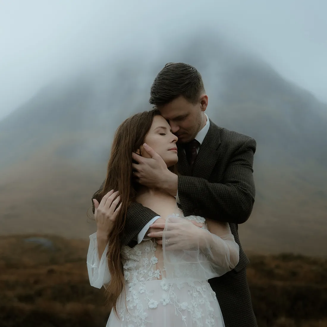 Bride and groom embracing each other on a foggy day in Glencoe