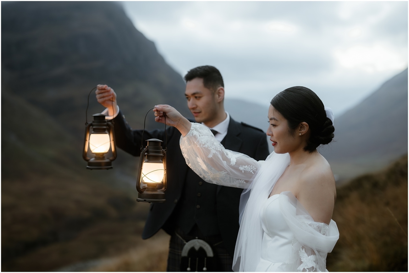 The couple lifting their lanterns, illuminating their serene and romantic moment in the twilight