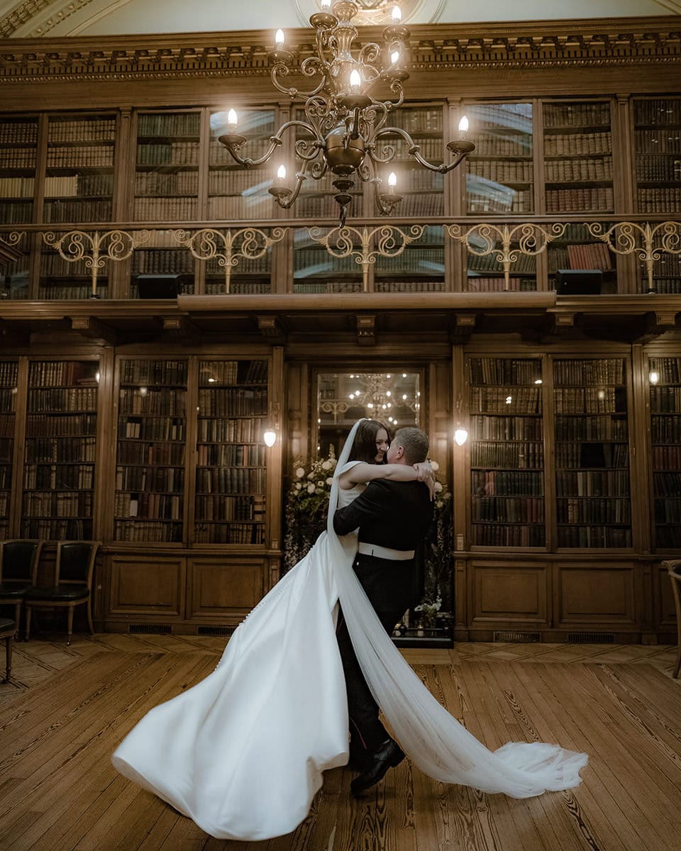 Bride and groom sharing their first dance beneath a chandelier in the New Library at the Royal College of Physicians Edinburgh