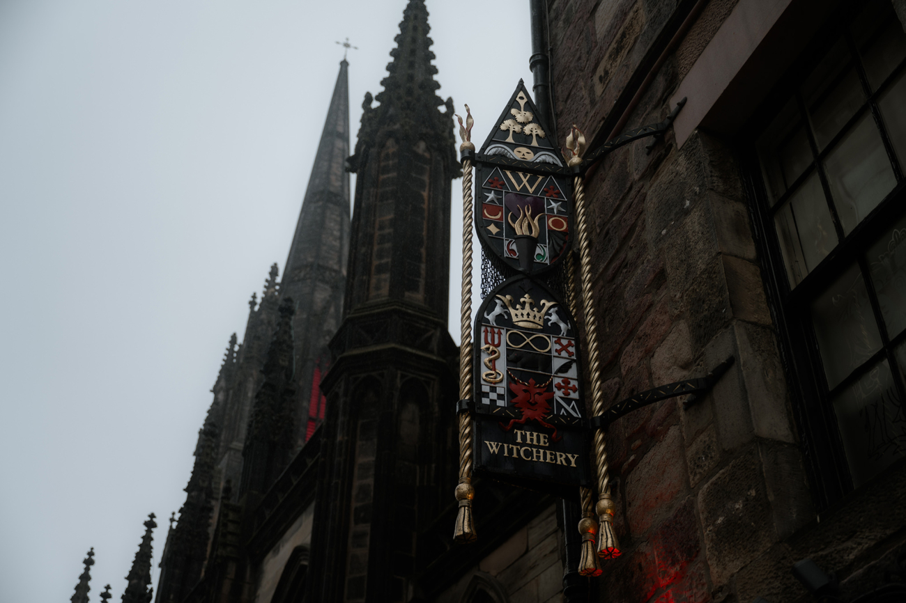 Crest of the Witchery on Edinburgh Royal Mile with cathedral tower behind it