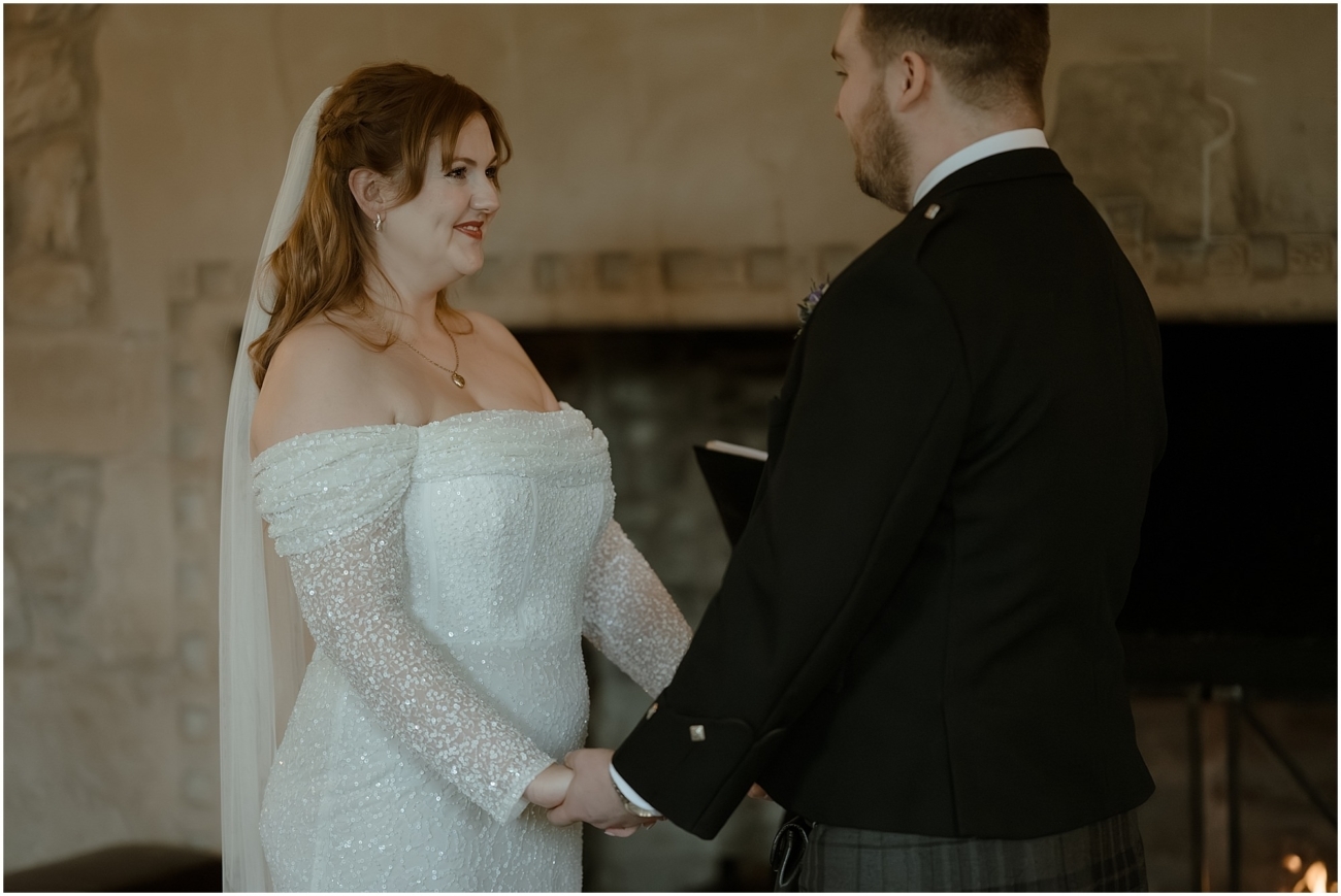 Cosy & Intimate Wedding at Ferniehirst Castle in the Scottish Borders 11 Bride and groom holding hands during their vows at Ferniehirst Castle