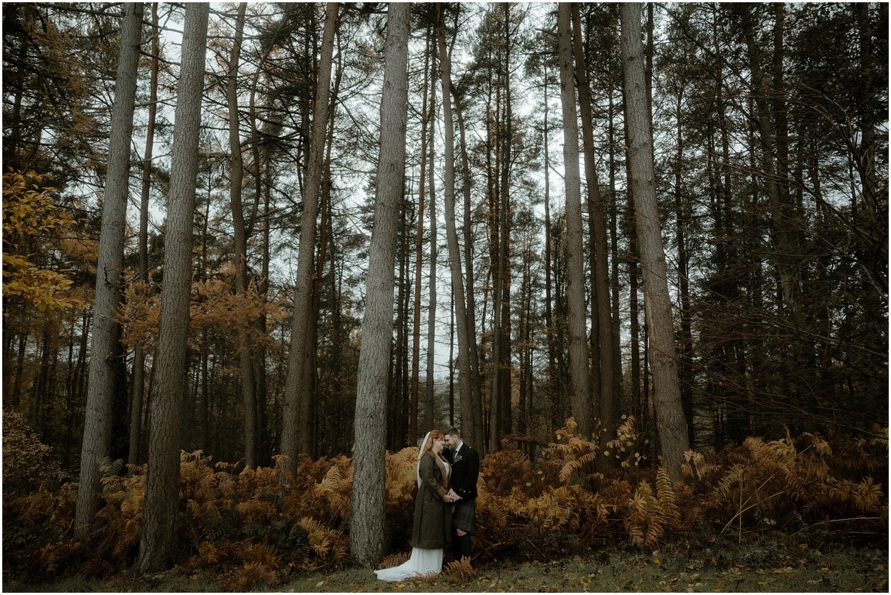 Cosy & Intimate Wedding at Ferniehirst Castle in the Scottish Borders 25 Wide woodland wedding portrait with tall trees near Ferniehirst Castle