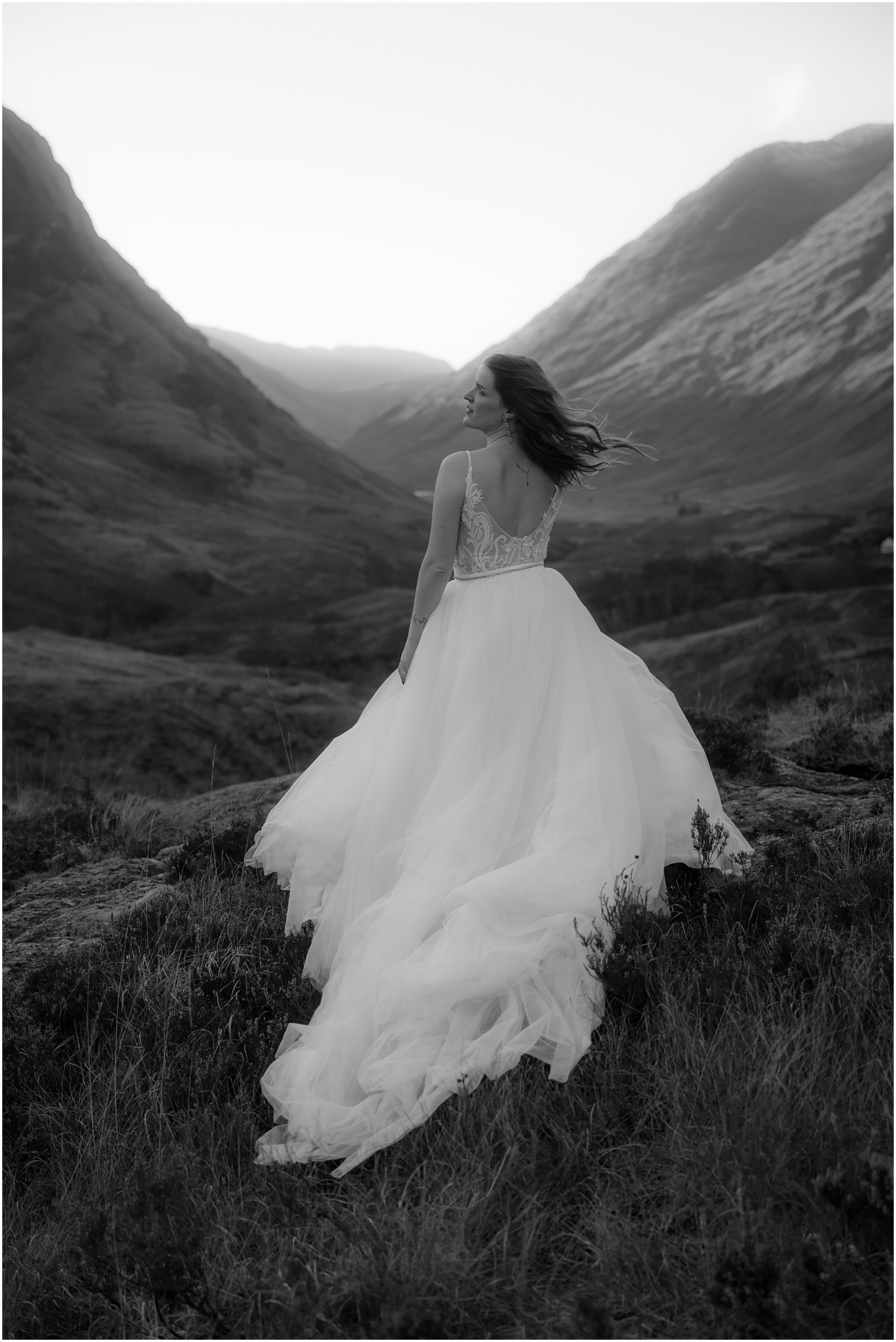 Steall Falls elopement in Glen Nevis 46 The bride stands alone in profile, her gown sweeping behind her as wind tousles her hair
