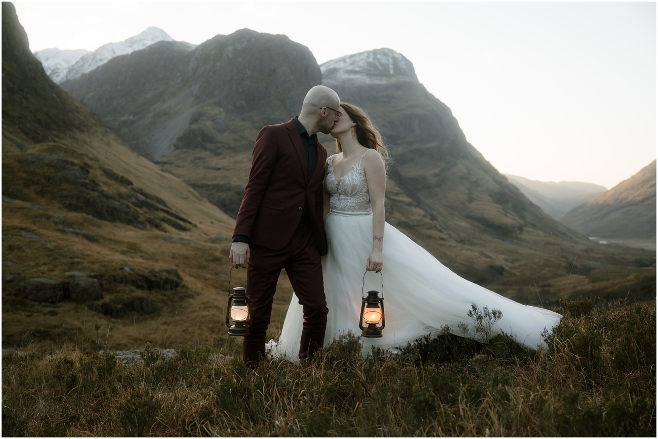 Steall Falls elopement in Glen Nevis 47 A tender kiss between the couple holding lanterns at sunset