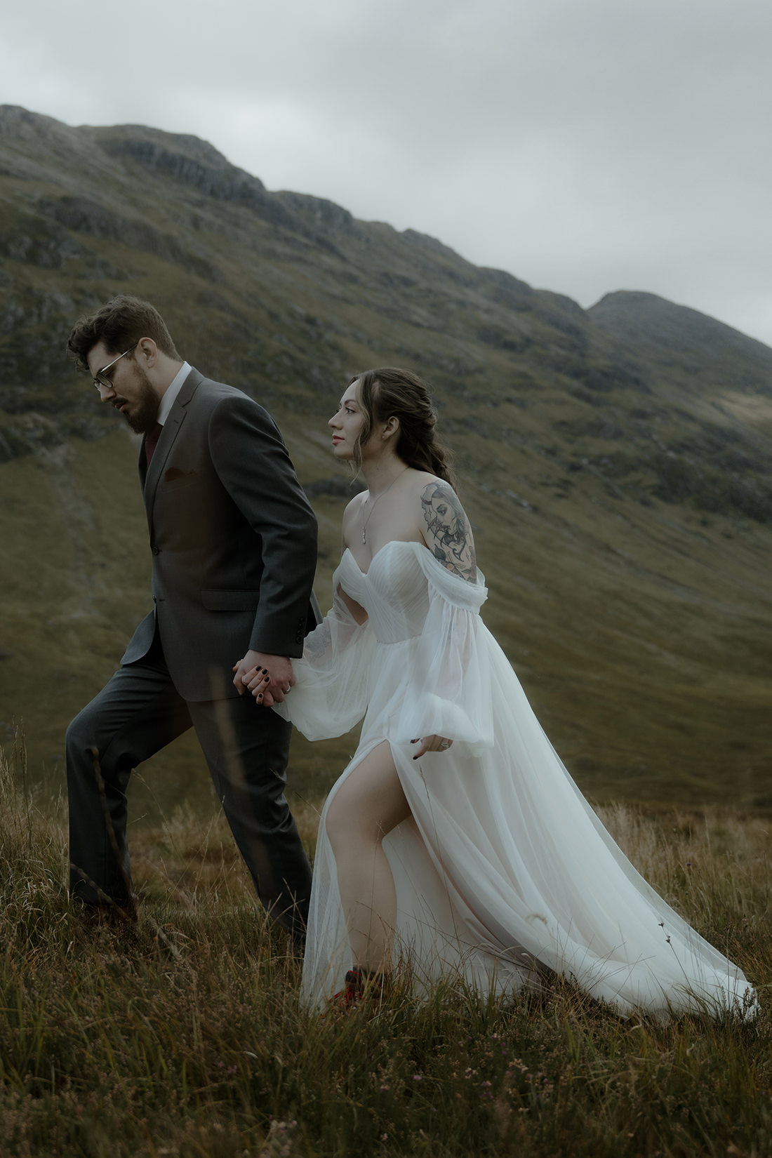 FAQ 1 Bride and groom holding hands and walking moors of the Scottish highlands together