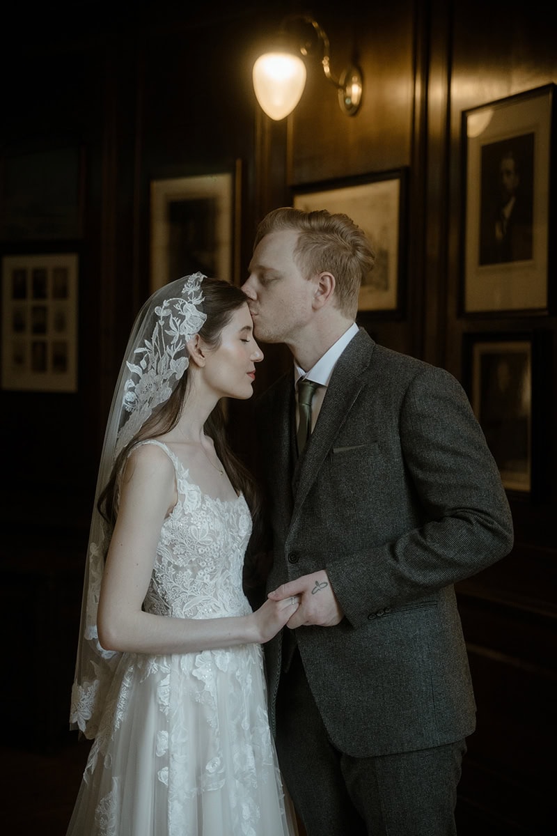 Weddings at the Royal College of Physicians Edinburgh: everything you need to know 4 Groom kissing bride on the forehead in the corridor at the Royal College of Physicians Edinburgh