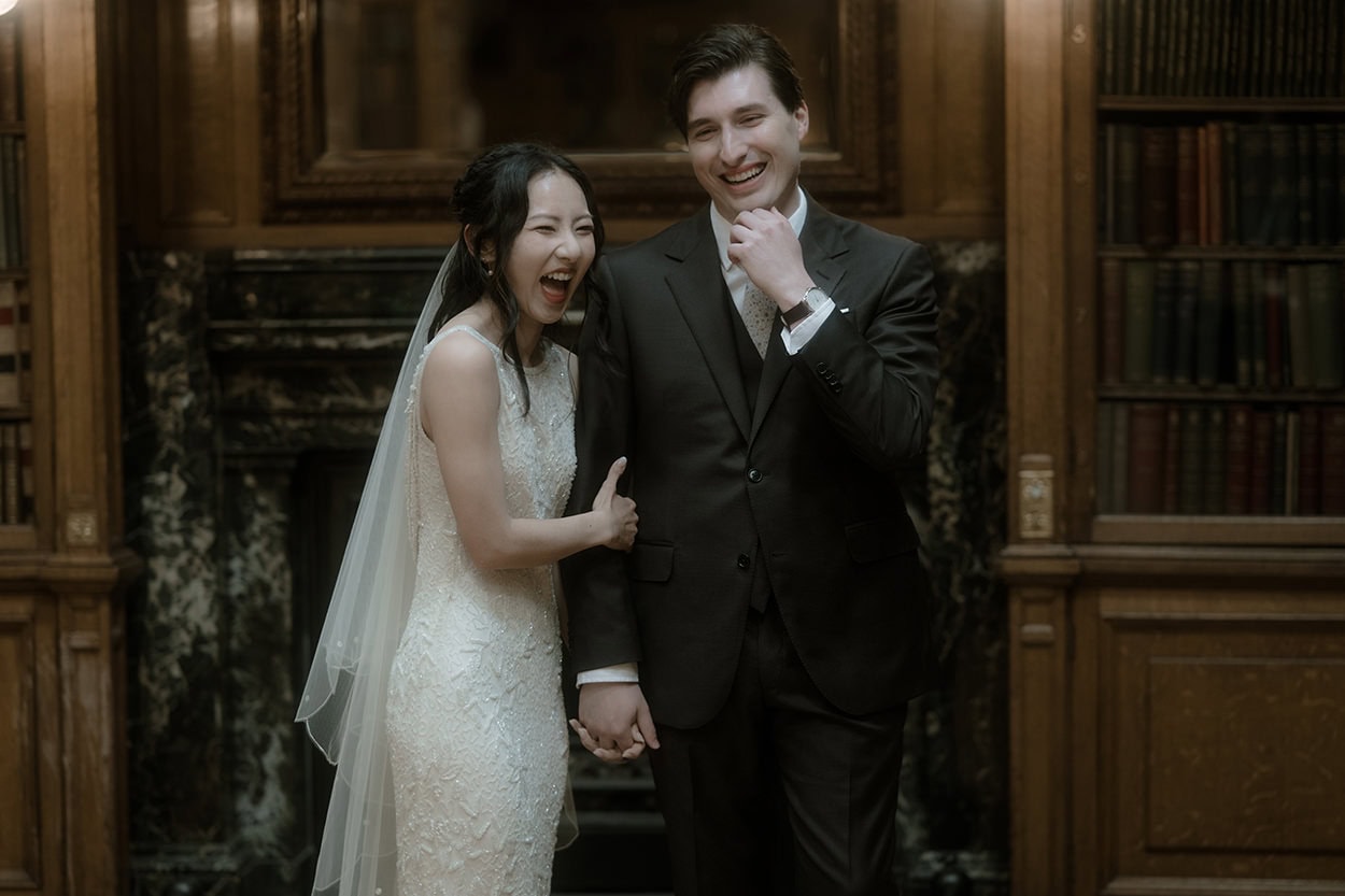 Weddings at the Royal College of Physicians Edinburgh: everything you need to know 11 Bride and groom laughing together in front of the Georgian fireplace in the New Library