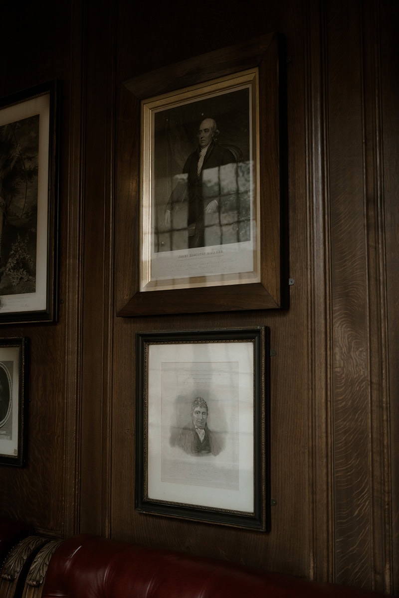 Weddings at the Royal College of Physicians Edinburgh: everything you need to know 3 Antique portrait paintings on dark wood panelled walls in the corridor at the Royal College of Physicians Edinburgh