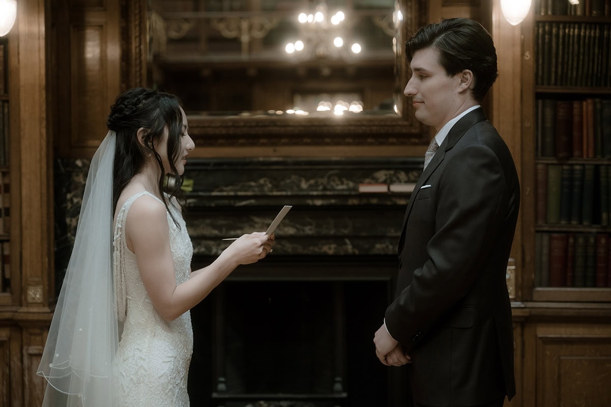 Bride reading personal vows to her groom in front of the Georgian fireplace in the New Library at the Royal College of Physicians Edinburgh