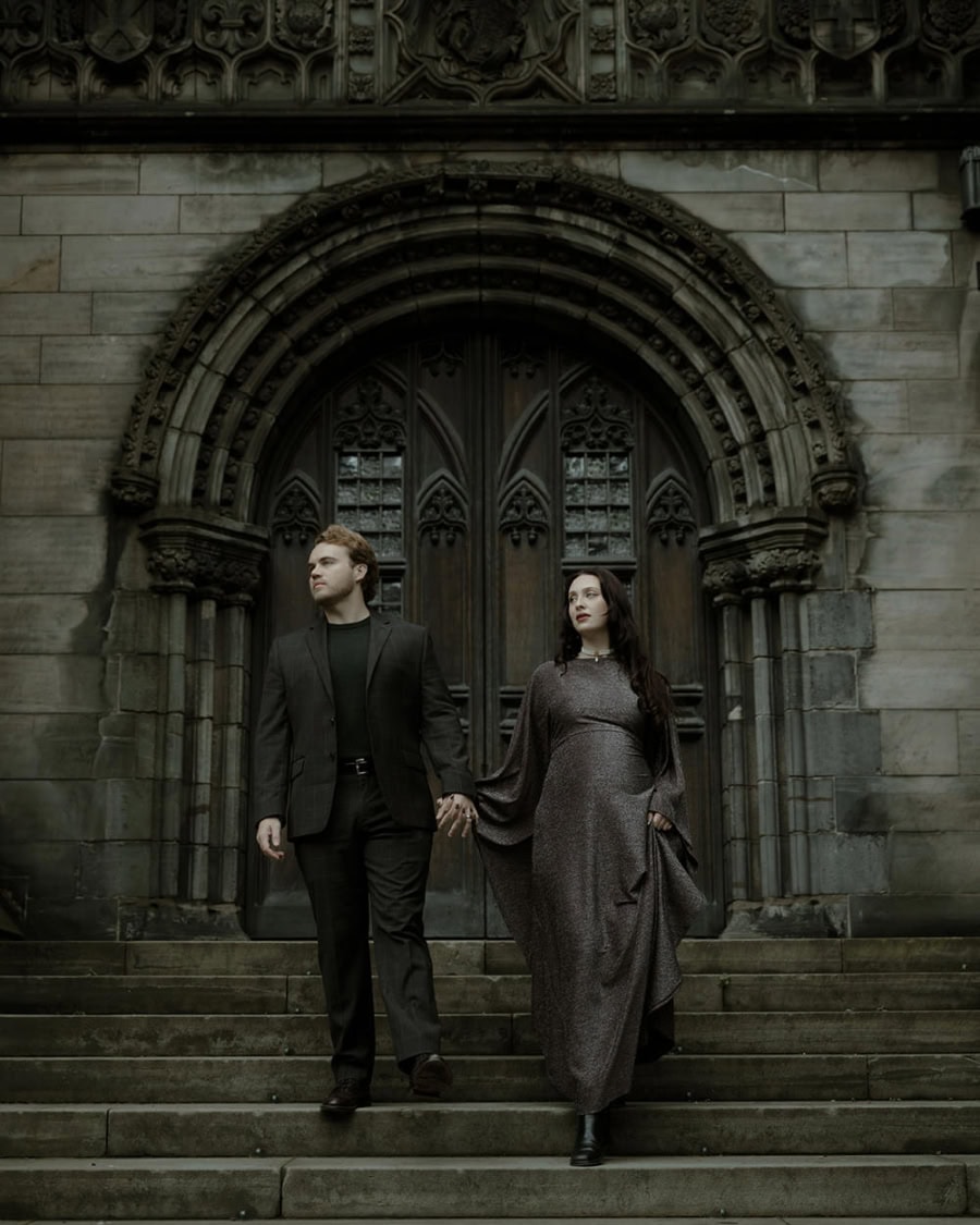 Bride and groom dressed in dark academia style aesthetic, walk down the steps of St Giles Cathedral in Edinburgh - gothic couple photo session Scotland